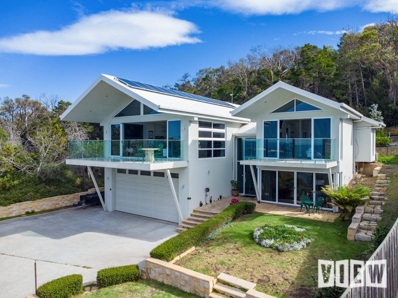 Modern white house with solar heating system and garage doors